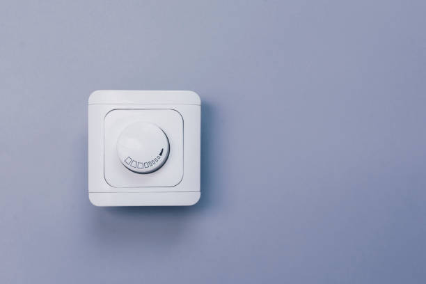 Dimmer Light Switch. A wall switch. Electrician switch. White rolling electricity switch Dimmer Light Switch. Electrician switch. White rolling electricity switch on bright wall dimmer switch photos stock pictures, royalty-free photos & images