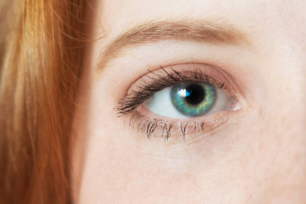 istock Young red-headed woman's eye stares at the camera in close-up 1173200294