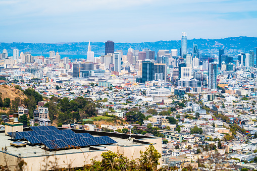 Amazing one of a kind view of renewable energy and climate change , sustainable living , Solar Panels on Rooftop with Twin Peaks View of San Francisco California Skyline Cityscape