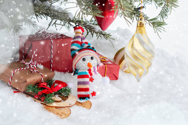 istock Christmas composition under the Christmas tree - a snowman, boxes with gifts on a sled and other decorations, place for text, copy space 1173205539