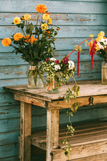 istock Fall flowers in glass jars standing on the table outside 1173208166