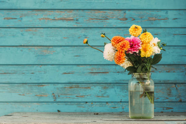 Fall flowers in glass jars standing on the table outside