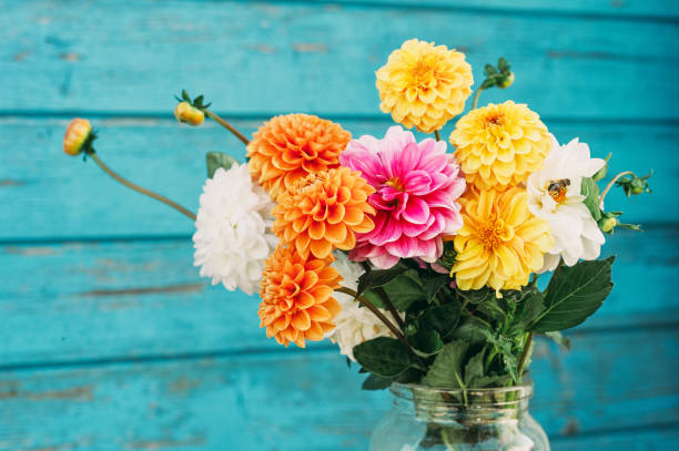 istock Fall flowers in glass jars standing on the table outside 1173208173