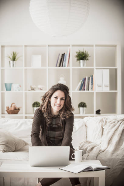 istock Young dark haired businesswoman working home after hours on her laptop computer 1173208910