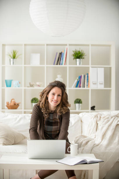 istock Young dark haired businesswoman working home after hours on her laptop computer 1173208913