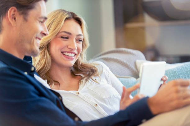 istock Worried couple looking at a digital tablet at home on the sofa. 1173220184
