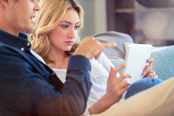 istock Worried couple looking at a digital tablet on the sofa. 1173220185
