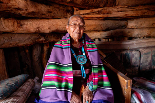 traditionelle authentische navajo ältere frau posiert in traditioneller kleidung in einem hogan in monument valley arizona - navajo american culture indigenous culture women stock-fotos und bilder