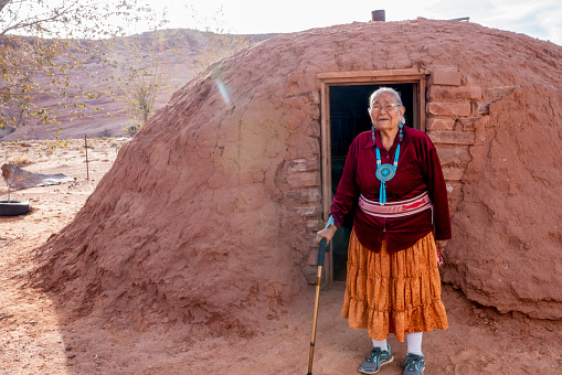 Tradicional Auténtica Navajo Mujer Mayor Posando ropa Tradicional cerca de un Hogan en Monument Valley Arizona photo