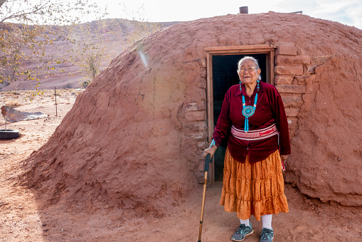 Traditional Authentic Navajo Elderly Woman Posing in Traditional Clothing near a Hogan in Monument Valley Arizona