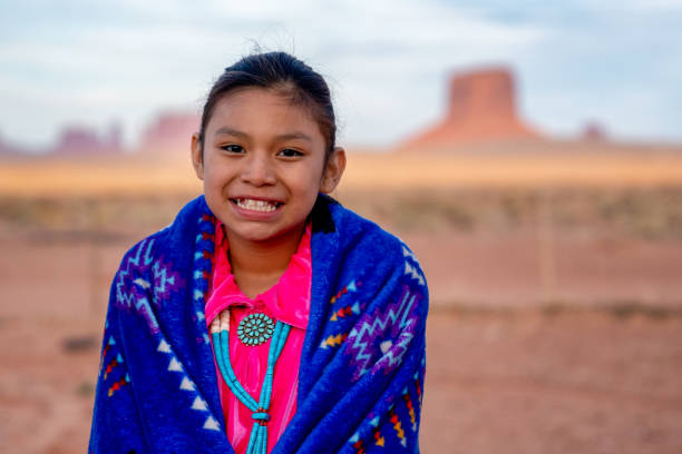 pretty nine year old native american navajo indian girl en las primeras horas de la mañana vestida con ropa tradicional posando frente al monument valley tribal park - cherokee fotografías e imágenes de stock