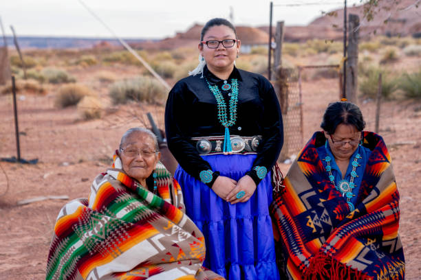 коренные американские женщины навахо, внучка-подросток, бабушка и прабабушка вне традиционного дома навахо в долине монумен�тов на границе  - cherokee стоковые фото и изображения