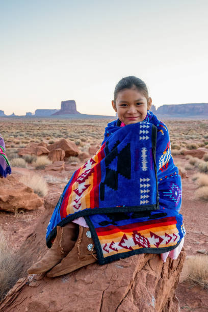 pretty nine year old native american navajo indian girl en las primeras horas de la mañana vestida con ropa tradicional posando frente al monument valley tribal park - north american tribal culture fotografías e imágenes de stock