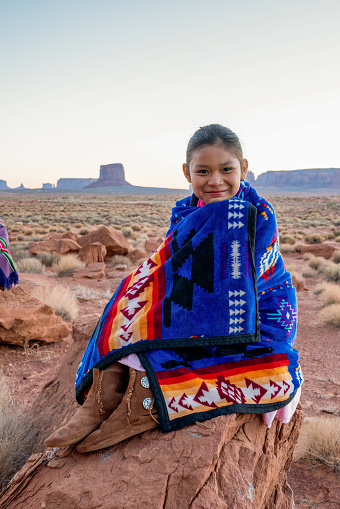 Pretty Nine Year Old Native American Navajo Indian Girl In the Early Morning Hours Dressed in Traditional Clothing Posing in Front of the Monument Valley Tribal Park