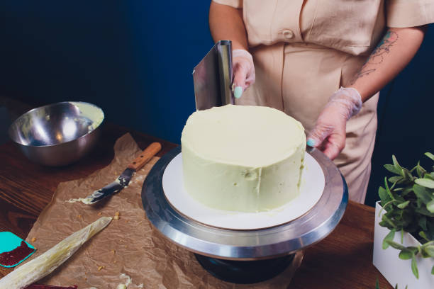 istock women's hands making biscuit cake with white cream using a cooking spatula. 1173223174