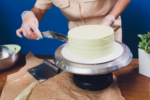 istock women's hands making biscuit cake with white cream using a cooking spatula. 1173223175