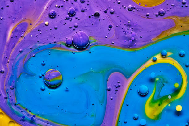 mixing blue yellow and purple color paints on blue background
