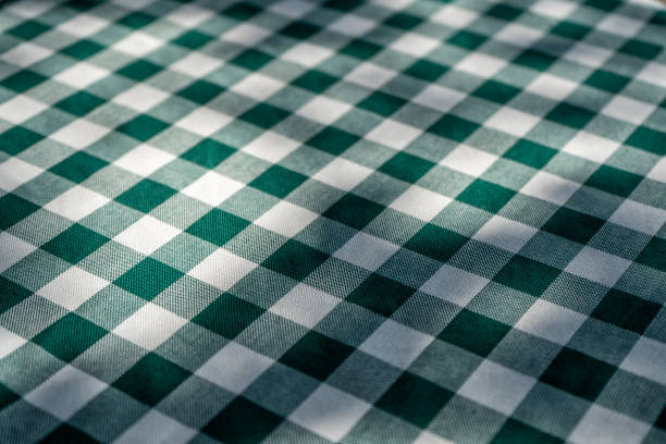 Empty table with green tablecloth over blur park background, for food and product display montage