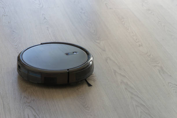 istock Robotic vacuum cleaner on laminate wood floor smart cleaning technology 1173226858