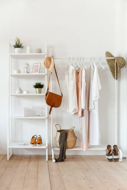 Clothing in trendy color hangs on a rack with accessories, and there is a rack with interior items stock photo