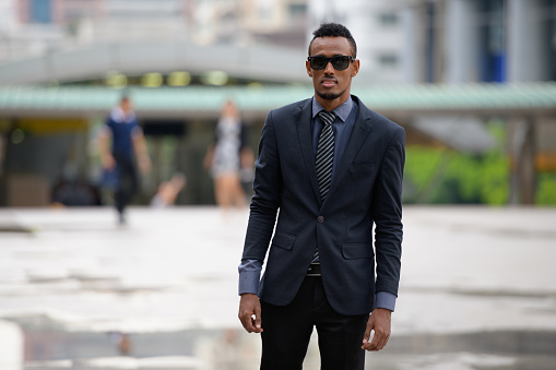 Portrait of young African businessman in the city streets outdoors