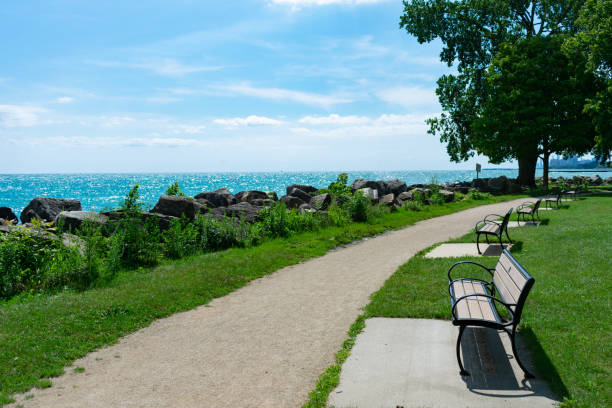 Benches at a Park along Lake Michigan in Evanston Illinois Empty wooden benches along a path at a park along Lake Michigan in Evanston Illinois during the summer lake michigan photos stock pictures, royalty-free photos & images