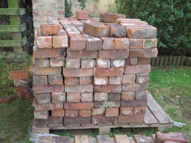 istock Old rustic bricks piled on pallet on green lawn 1173255726