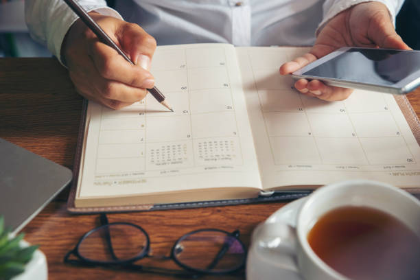 Female'hand of planner writing daily appointment. On 2020 Calendar book,Female'hand of planner writing daily appointment.Woman mark and noted schedule(holiday trip) on diary at office desk.Calendar reminder event for planner concept personal organiser stock pictures, royalty-free photos & images