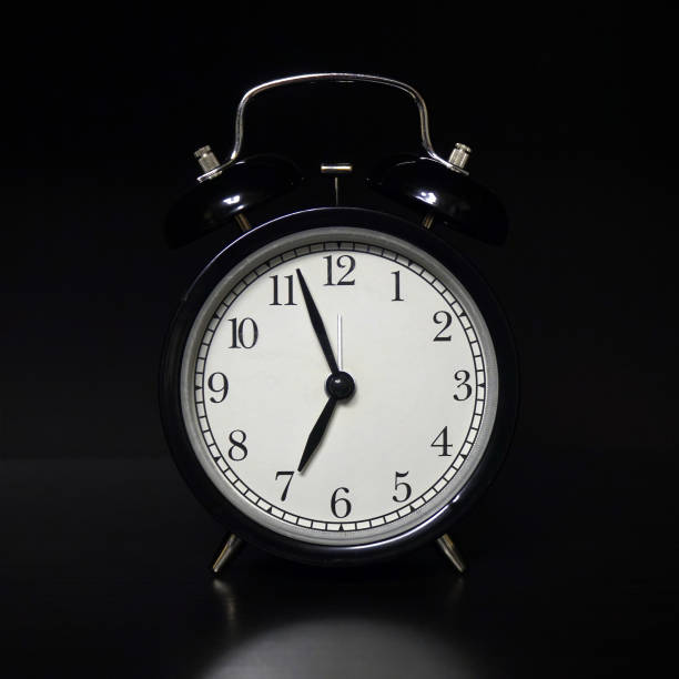 istock Classic mechanical alarm clock on dark background 1173259006