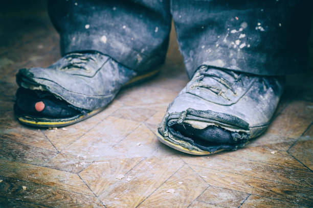 istock Old torn boots on the man's feet 1173259018