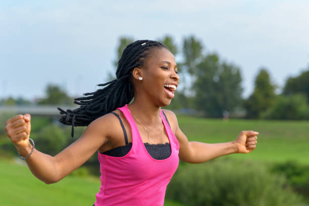 istock Vivacious young African woman cheering as she runs 1173260099