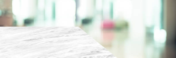 istock marble table top product display background with blur business office hallway.left perspective stone kitchen counter with people waiting doctor in hallway.Banner mockup presentation 1173261427