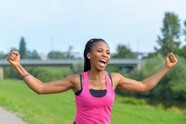 istock Vivacious young African woman cheering as she runs 1173261463