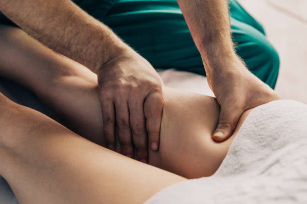 Lymphatic drainage massage of the hips. A male massage therapist gives a massage to a young woman Lymphatic drainage massage of the hips. A male massage therapist gives a massage to a young woman Lymphatic Drainage Massage stock pictures, royalty-free photos & images