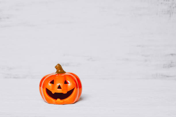 istock Orange ghost pumpkins on grunge rusty white wooden borad background with copy space for your text. halloween background minimal concept. 1173262503