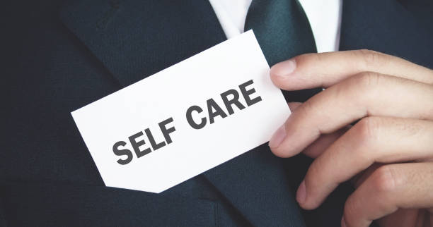 istock Man holding Self Care text on business card. 1173262850