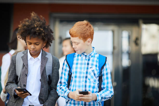 istock Two boys playing on mobile phones 1173266484