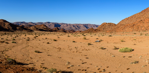 A valley in the barren border area between South Africa and Namibia near Klein Pella, Northern Cape. An offload vehicle in middle ground