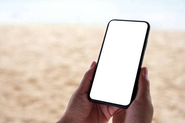 istock hands holding black mobile phone with blank desktop screen by the sea 1173268369