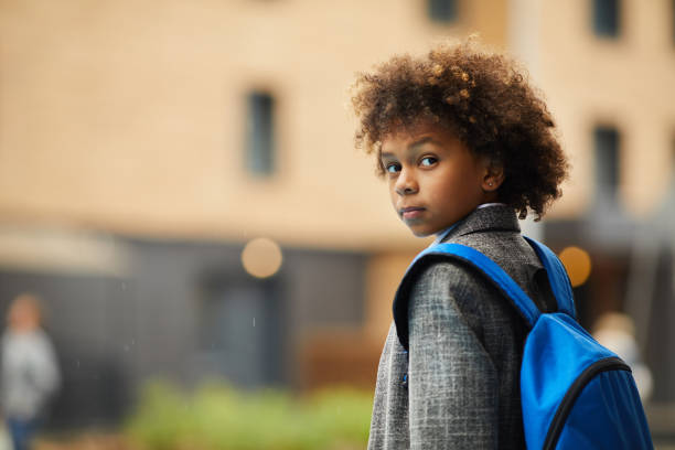 African schoolboy with backpack outdoors