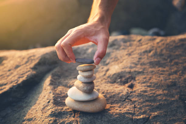 istock man hand stone tower on the beach 1173275486