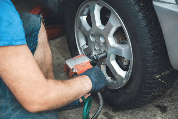 istock car mechanic screwing a car wheel 1173275502