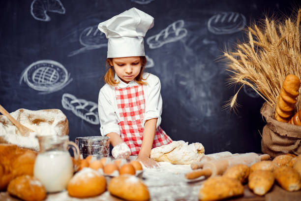 istock Adorable little girl in chef hat making dough 1173276039