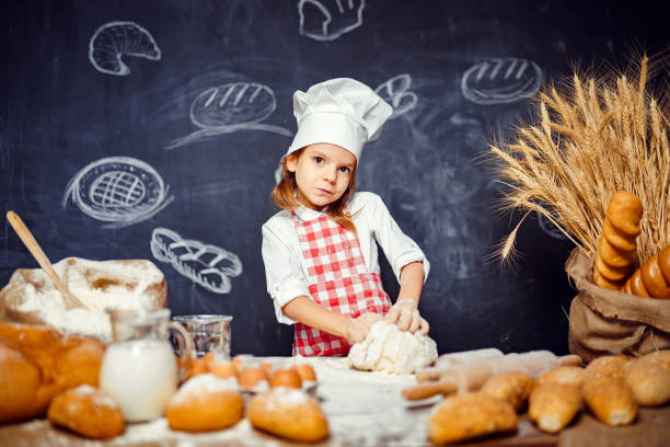 istock Adorable little girl in chef hat making dough 1173276102
