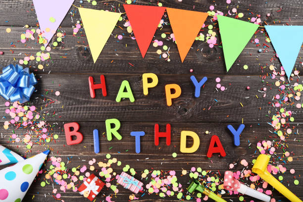 istock Text Happy Birthday by plastic letters with decorations and confetti on brown background 1173276118