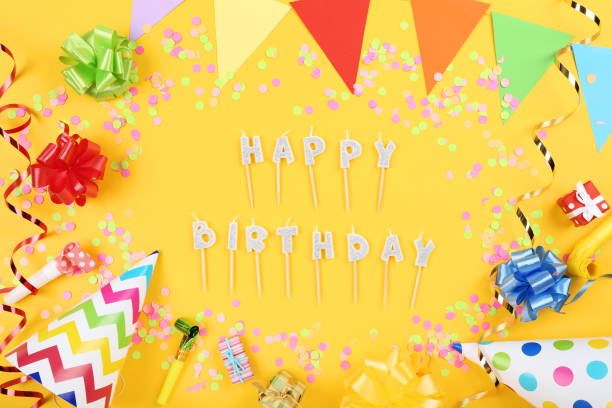 istock Happy Birthday candles with party decorations on yellow background 1173276237