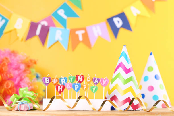 istock Happy Birthday candles with party decorations on yellow background 1173277028