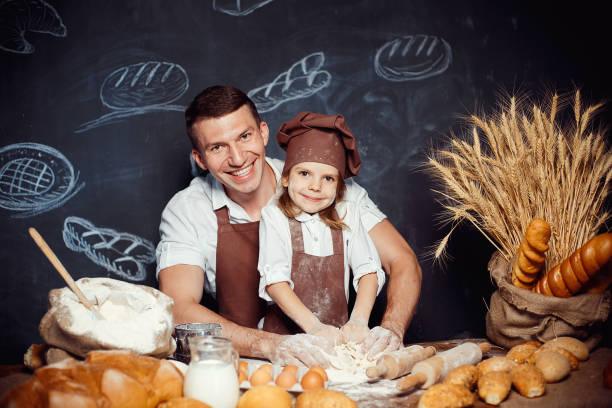 istock Little girl with father making dough 1173277344