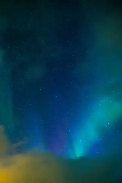 Photo of Aurora Borealis Known as Nother Lights Playing with Vivid Colors Over Lofoten Islands in Norway. Vertical Image Composition