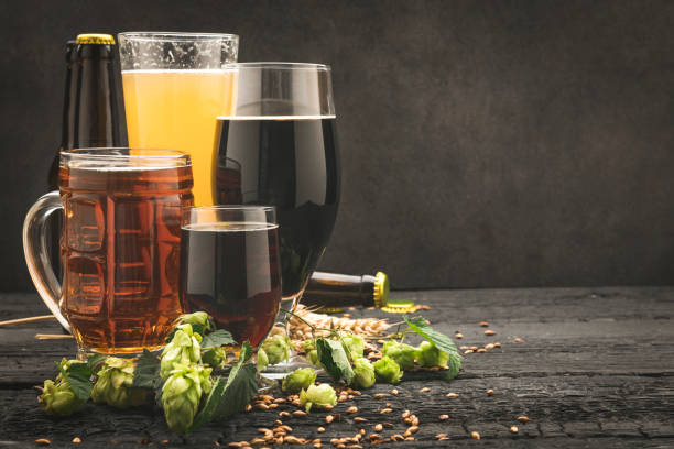 istock Beer glass surrounded by hops on wooden background 1173282682